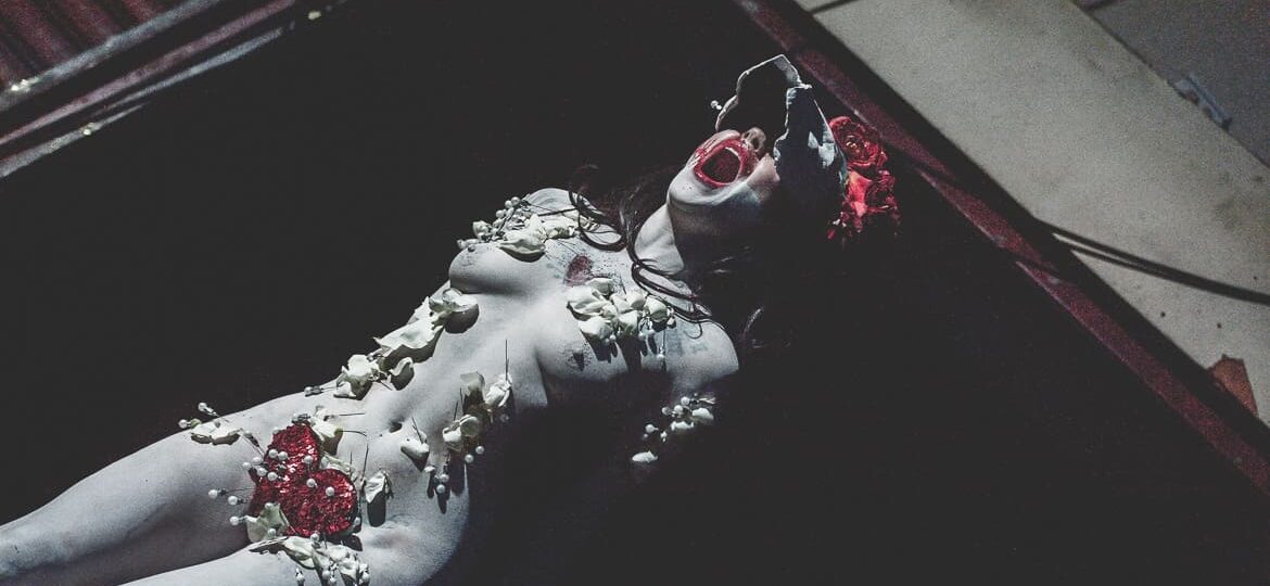 Performance artistique dramatique avec maquillage et accessoires.