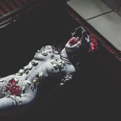 Performance artistique dramatique avec maquillage et accessoires.