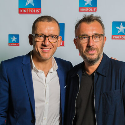 Deux hommes devant un logo Kinepolis.