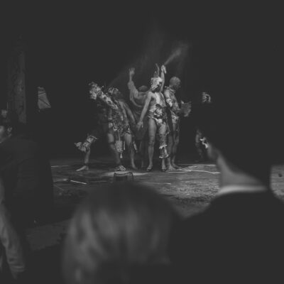 Performance artistique en noir et blanc, public observant.