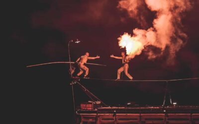 Équilibriste sur fil avec flamme spectaculaire.