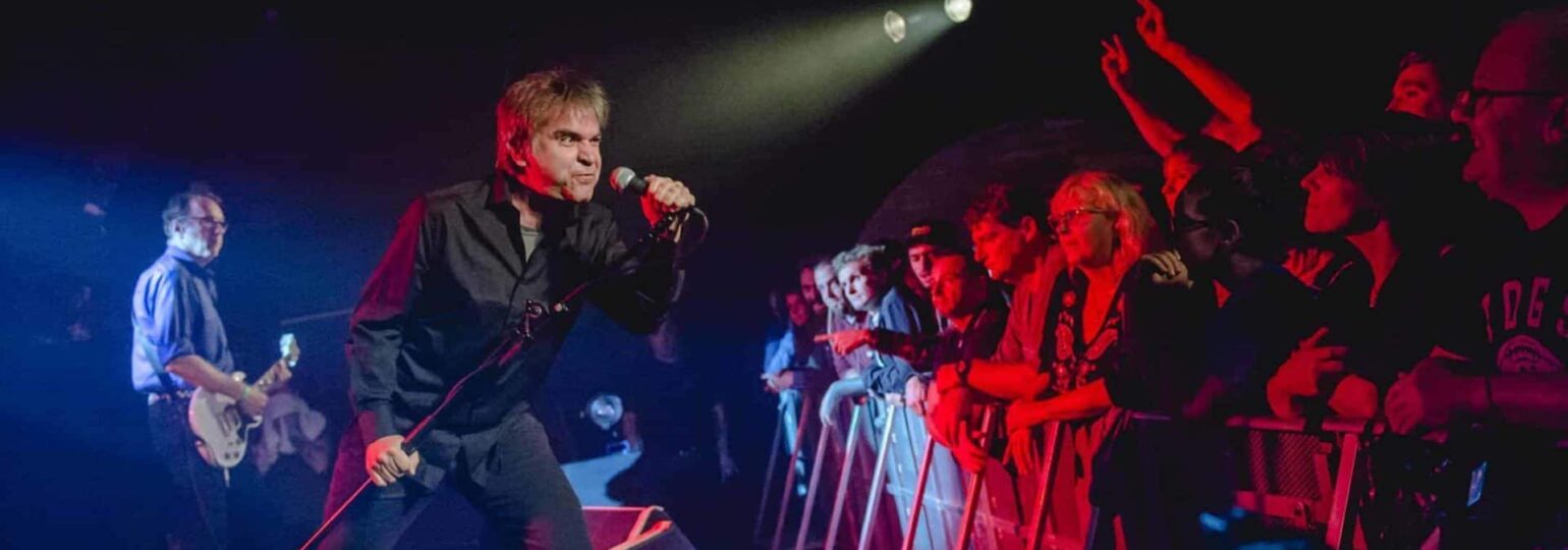 Chanteur en concert devant un public enthousiaste.