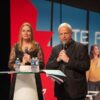 Deux personnes parlent sur scène avec micros.