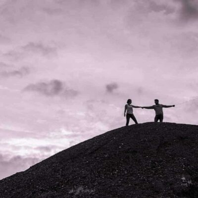 Deux personnes avec ballon sur colline sombre.