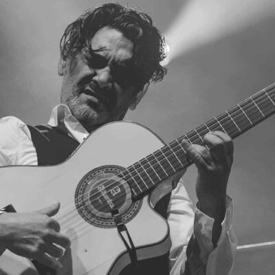 Musicien jouant de la guitare sur scène.