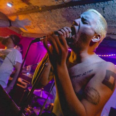 Concert rock underground avec chanteur tatoué.