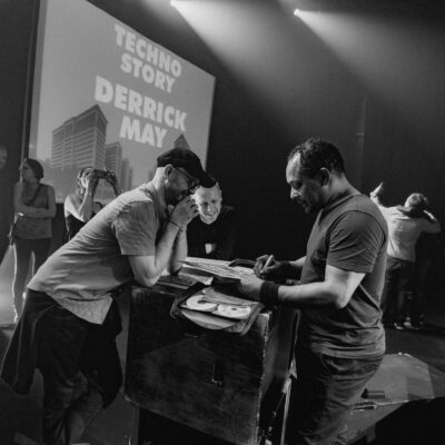 Concert techno avec artistes sur scène.