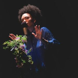 Personne chantant au micro avec décor floral.