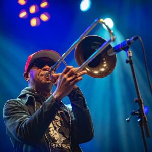 Musicien jouant du trombone sur scène en concert.