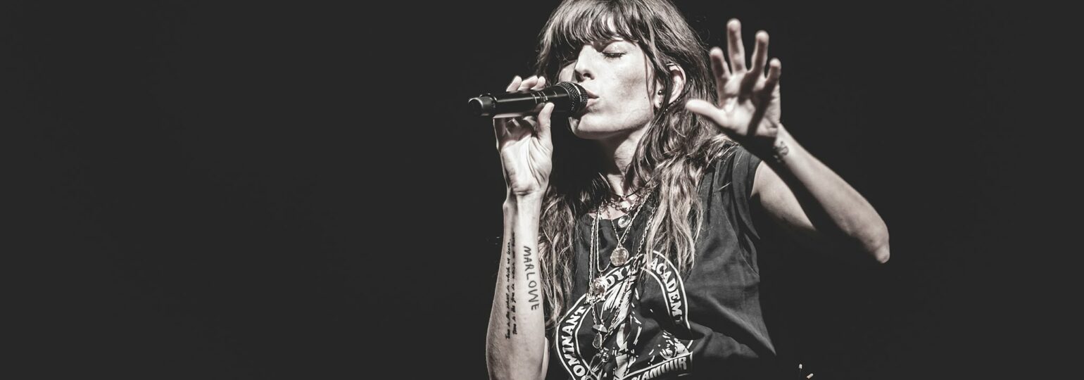 Femme chantant sur scène avec un micro.