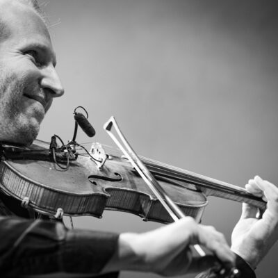 Homme jouant du violon sur scène.