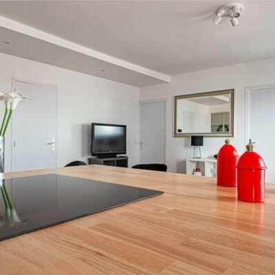 Cuisine moderne avec îlot et décoration rouge.