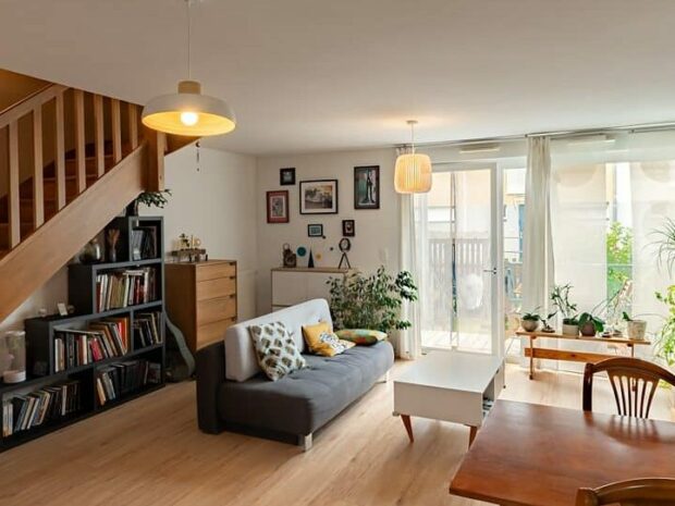 Salon moderne avec escalier et plantes.