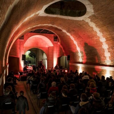 Concert dans une voûte éclairée en rouge.