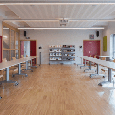 Salle de réunion avec tables et chaises modernes.