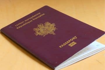 Passeport français sur une table en bois.