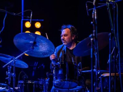 Homme jouant de la batterie sur scène.