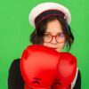 Personne avec gants de boxe rouges, fond vert.