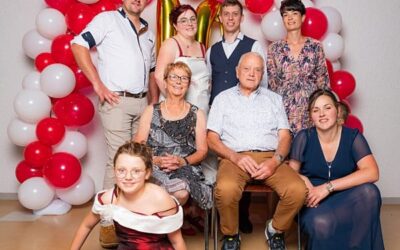 Groupe de personnes devant des ballons rouges et blancs.