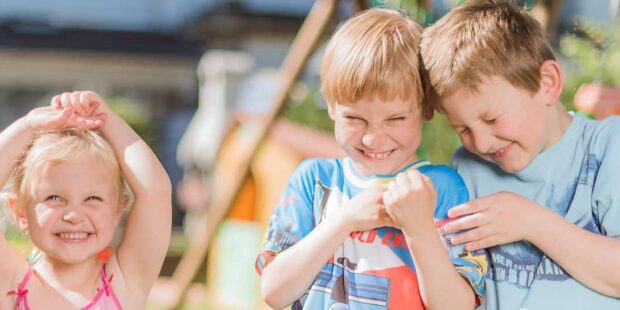 Enfants souriant et jouant dehors en été.