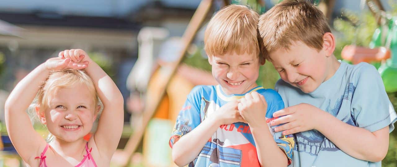 Enfants souriant et jouant dehors en été.