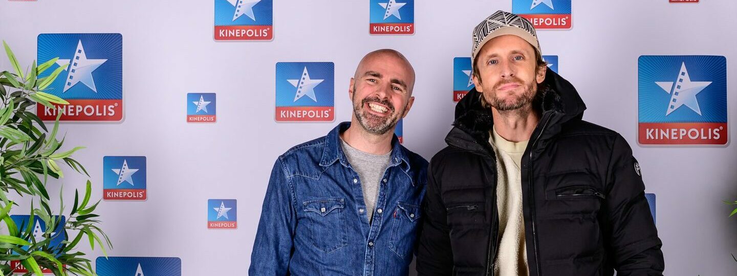 Deux personnes posent devant un logo Kinepolis.