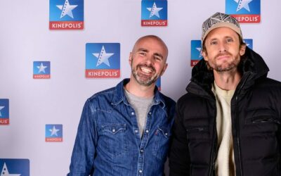 Deux personnes posent devant un logo Kinepolis.