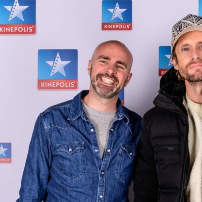 Deux personnes posent devant un logo Kinepolis.