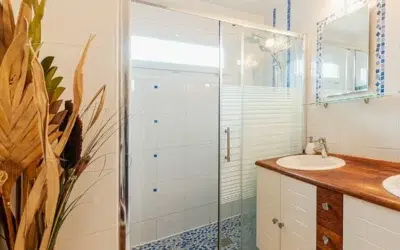 Salle de bain moderne avec douche et double vasque.