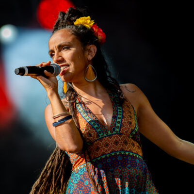 Chanteuse sur scène avec micro et robe colorée.