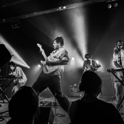 Concert de rock avec éclairage intense et musiciens.