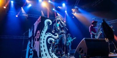 Groupe jouant en concert avec éclairage vibrant.