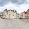 Rue pavée avec bâtiments historiques, ciel nuageux