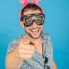 Homme souriant, oreilles roses, lunettes de plongée.