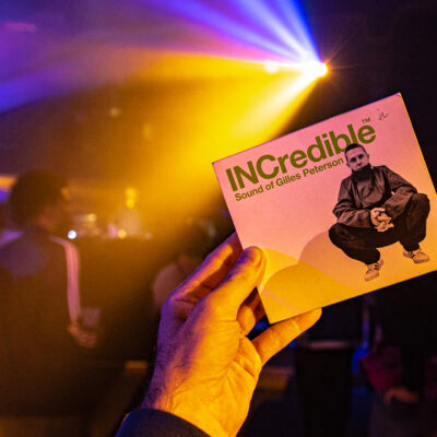 Main tenant un album dans un club lumineux.