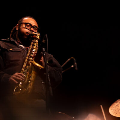 Musicien jouant du saxophone sur scène.