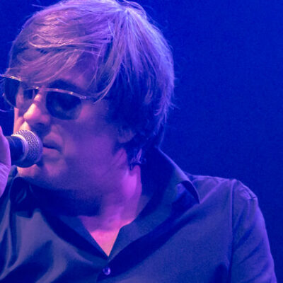Chanteur sur scène avec lunettes de soleil.