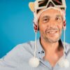 Homme souriant portant un chapeau ludique.