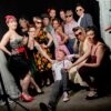 Groupe de femmes et homme posant dans un studio.