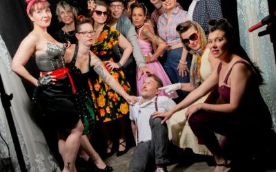 Groupe de femmes et homme posant dans un studio.