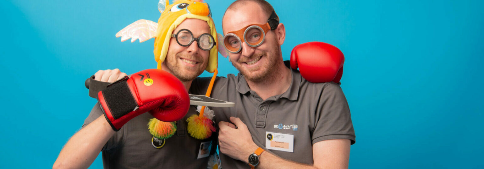 Deux hommes souriant avec déguisements et jouets.