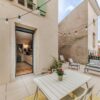 Terrasse avec mobilier et guirlandes lumineuses.