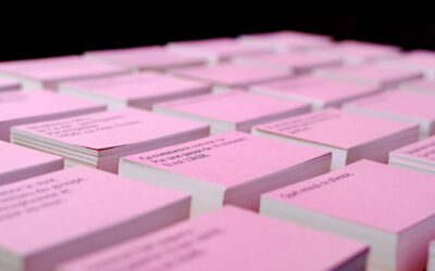 Cartes roses empilées avec texte visible.