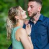 Couple s'enlaçant dans un parc verdoyant.