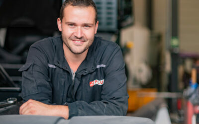 Homme souriant dans un atelier de réparation.