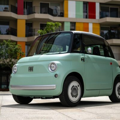Petite voiture électrique verte, architecture colorée.