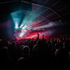Concert avec foule et jeux de lumières rouges.