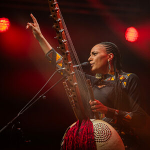 Musicienne jouant de la kora sur scène.