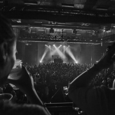 Concert en noir et blanc avec public enthousiaste.