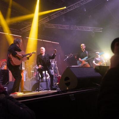 Concert avec groupe jouant sur scène éclairée.